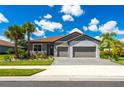 Well-manicured landscaping adds to the curb appeal of this charming home with a brick driveway and two-car garage at 7323 Great Egret Blvd, Sarasota, FL 34241
