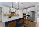 A modern kitchen with quartz countertops, stainless steel appliances, pendant lighting and a center island at 7323 Great Egret Blvd, Sarasota, FL 34241