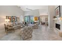 Well-lit living room featuring a fireplace, high ceilings, tile floors and sliding glass doors to a patio at 7344 Villa D Este Dr, Sarasota, FL 34238