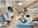 Open-concept living room featuring a fireplace, hardwood floors, and comfortable seating at 8811 White Sage Loop # 8811, Lakewood Ranch, FL 34202