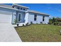 Single-story home with light blue exterior, white garage door, and well-manicured lawn at 9245 Zorn St, Port Charlotte, FL 33981