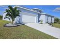Newly built home with light blue exterior, white garage door, and neatly landscaped yard at 9245 Zorn St, Port Charlotte, FL 33981