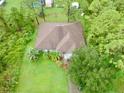 Single-story house with a brown roof, surrounded by lush green trees and lawn at 3401 Schuster St, North Port, FL 34291