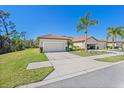 Two-car garage and driveway with green lawn at 2539 Thyme Way, North Port, FL 34289