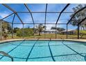 Inviting screened-in pool with a view of the backyard and surrounding homes at 745 Columbia St, Port Charlotte, FL 33948