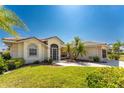 Single-story home with tile roof, landscaped lawn, and palm trees at 16446 Belo Ct, Punta Gorda, FL 33955