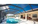 Enclosed kidney-shaped pool with patio furniture and covered lanai at 16446 Belo Ct, Punta Gorda, FL 33955