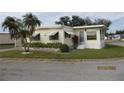 Attractive yellow mobile home with palm trees and well-maintained landscaping at 6405 Kilohee Ct, North Port, FL 34287