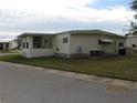 Side view of a single-wide mobile home showing a large window and AC unit at 6405 Kilohee Ct, North Port, FL 34287