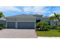 Gray two-story house with three car garage and landscaping at 25133 Longmeadow Dr, Punta Gorda, FL 33955