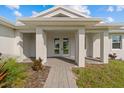 Covered front porch entry with double French doors at 8136 Welsford Rd, Port Charlotte, FL 33981