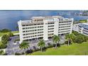 Aerial view of waterfront building with parking and tropical landscaping at 1500 Park Beach Cir # 2F, Punta Gorda, FL 33950