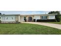 Single-story home with stone accents and a well-manicured lawn at 22580 Bolanos Ct, Port Charlotte, FL 33952