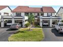 Exterior view of townhomes showcasing individual garages, landscaped yards, and upper-level balconies at 754 Avenida Estancia # 160, Venice, FL 34292