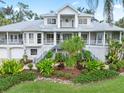 Two story house with gray metal roof, white siding, and lush landscaping at 116 Dolly St, Punta Gorda, FL 33950