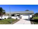 White single story house with a gray roof, driveway, and lawn at 20430 Edgewater Dr, Port Charlotte, FL 33952