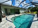 Enclosed pool with gray tile deck and tropical landscaping at 4767 Maurbach Ter, North Port, FL 34286