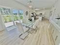 Bright dining area with modern chandelier, large glass table and light colored wood flooring at 3140 Sweet Gum Dr, Punta Gorda, FL 33982
