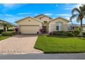 Charming home with a brick driveway, lush green lawn, and well-manicured landscaping at 24723 Rio Villa Lakes Cir, Punta Gorda, FL 33950