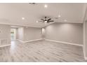 Spacious living room featuring gray vinyl floors, recessed lights, and modern ceiling fan at 25118 Alcazar Dr, Punta Gorda, FL 33955