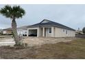 New construction home showcasing a tan exterior, attached garage, and a palm tree at 4250 Oak Terrace Cir, Port Charlotte, FL 33953