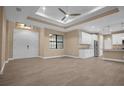 Open living room features a coffered ceiling, tile floors, and a view of the kitchen at 13164 Amaryllis Cir, Port Charlotte, FL 33981