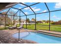 Relaxing pool area with screened enclosure, patio furniture, and golf course view at 1736 Suzi St, Punta Gorda, FL 33950
