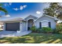 Two-car garage, gray house with well-maintained lawn at 5255 Drew Rd, Venice, FL 34293