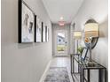 Bright entry hall with tile flooring, console table, and framed art at 5096 Schubert Trl, North Port, FL 34287