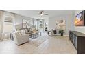 Spacious living room with large windows, plush seating, and wood-look floors at 5096 Schubert Trl, North Port, FL 34287
