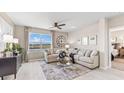 Spacious living room features a large window with water view, comfortable seating, and a ceiling fan at 9572 Turtle Grass Cir, Punta Gorda, FL 33950