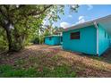 Teal house exterior with a yard and trees at 350 Gill St, Punta Gorda, FL 33950