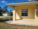 Exterior corner showing the neutral paint scheme and white trim, with a glimpse of the detached garage in the background at 12070 Surrey Ave, Port Charlotte, FL 33981