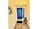 Inviting entryway with a blue front door and tiled flooring at 98 Seasons Dr, Punta Gorda, FL 33983