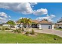 Well-maintained single-story home featuring a two-car garage, beautiful landscaping, and a circular driveway at 98 Seasons Dr, Punta Gorda, FL 33983