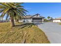 House with a gray exterior, palm trees, and a long driveway at 2387 Tamarind St, Port Charlotte, FL 33948