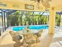 Covered patio with poolside seating overlooking refreshing pool at 279 Mariner Ln, Rotonda West, FL 33947