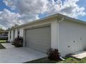A detached single-car garage with a long driveway, a neutral exterior, and a well-kept lawn with minimal landscaping at 20399 Ladner Ave, Port Charlotte, FL 33954