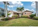 Tan house with palm trees, landscaped yard, and attached garage at 3310 Tripoli Blvd, Punta Gorda, FL 33950