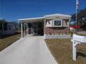 Mobile home exterior with covered carport, landscaping, and stone accents at 6603 Hauli Ct, North Port, FL 34287