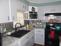 Galley kitchen with stainless steel appliances and granite countertops at 6603 Hauli Ct, North Port, FL 34287