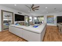 Bright living room featuring wood flooring, a large comfy sofa, and a view of the outdoor patio at 25228 Nocturne Ln, Punta Gorda, FL 33983