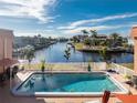 Relaxing view of refreshing pool and peaceful canal, with lush tropical landscape at 1345 Mediterranean Dr # A203, Punta Gorda, FL 33950