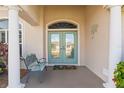 Inviting front entry with double doors and a charming bench at 219 White Marsh Ln, Rotonda West, FL 33947