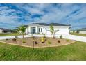 Modern two-story home with white exterior, two-car garage, and lush landscaping at 425 Orinoco St, Punta Gorda, FL 33983