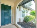 Close-up of the front door and entryway of the home with garden views at 1190 Victoria Ave Nw, Port Charlotte, FL 33948