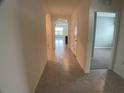 Bright and spacious hallway with tile flooring, leading to other rooms in the house at 2201 Grand Flora Trl, Bradenton, FL 34208