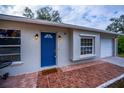 Updated house exterior with a blue door and terracotta tile walkway at 4485 Herder St, Port Charlotte, FL 33948