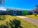 Charming single-story home with bright green exterior paint, screened in porch and a spacious driveway at 30431 Holly Rd, Punta Gorda, FL 33982