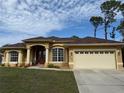 Tan house with a brown tile roof, two-car garage, and well-maintained lawn at 3100 Sheboygan Ave, North Port, FL 34286